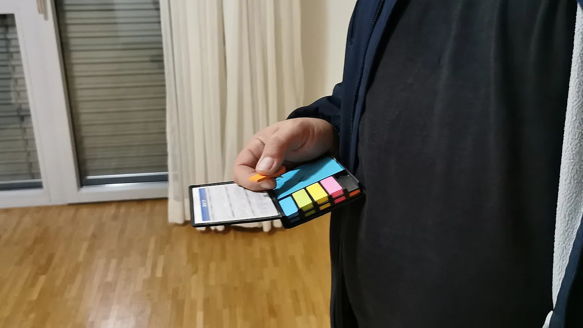 Enver Rexhepi hält mehrere Post-it in der Hand.